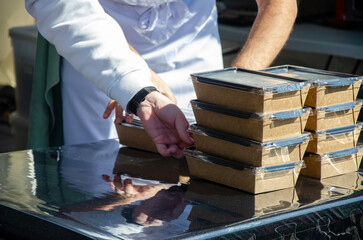 Close-up of prepared food placed in containers at an outdoor open kitchen