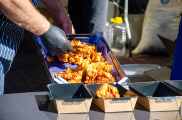 Close-up of prepared food placed in containers at an outdoor open kitchen