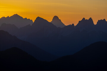 Sunset in the Dolomites beautiful landscape with mountain silhouettes and burning red light sky on the background. Sunrise and sunset in the Doloiti Alps