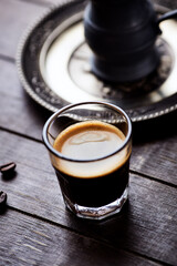 Coffee in glass cup on dark background. Close up. Copy space.