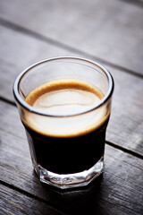 Coffee in glass cup on dark background. Close up. Copy space.
