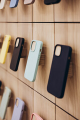 Assortment of protective cellphone phone cases in electronics shop interior.