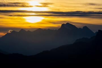 Sunset in the Dolomites beautiful landscape with mountain silhouettes and burning red light sky on the background. Sunrise and sunset in the Doloiti Alps