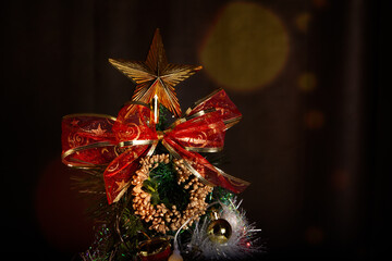 Decoration details of a Christmas tree decorated in red and gold.