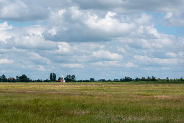 Typical Dutch polder landscape with clouds and sailboat at nature reserve Bloksloot (Bloksleat), Friesland, the Netherlands