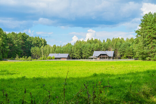 Typical traditional Lithuanian dwelling as a wooden house in with a road in summer with blue sky in Palū&scaron;ė, Ignalina district, Lithuania