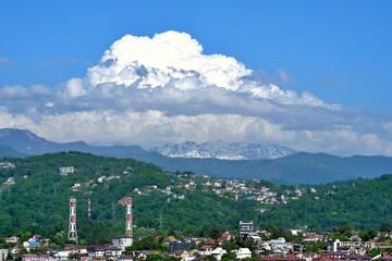 A sunny city in the mountains with big white clouds