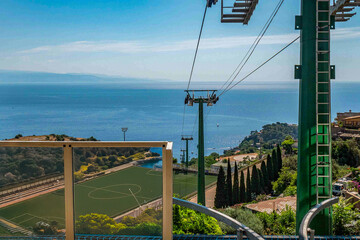 Fototapeta premium Téléphérique de Taormina avec vue sur la mer et un terrain de sport