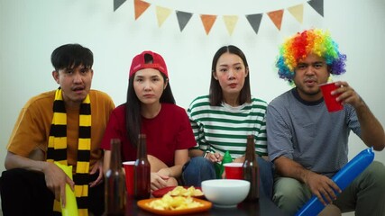 Group of friends man and woman watching live streaming cheering football match on TV at home. Eating snack and drinking beer. Sport fans people shouting and celebrating sport team victory match.
