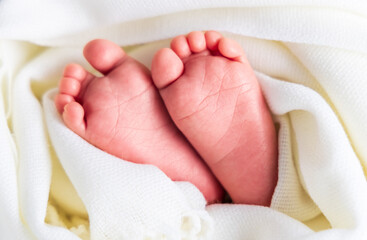 the feet of a newborn baby wrapped in heart-shaped cloth