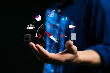 Compass for navigation, direction of business strategy to achieve the highest goal,  of personnel control, scheduling and public relations, businessman set the compass to guide to success. Dark tone