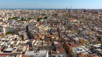 Obraz premium Aerial view of houses, buildings, apartments and roofs in Andria, Puglia, Italy. In background is the Mediterranean sea.