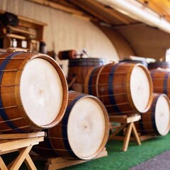 Extreme wide shot of an Oktoberfest tent, with a close-up focus on a row of traditional Bavarian drums lined up on the stage. The texture of the drumheads and wooden rims are sharp, as the colorful te