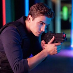 Naklejka premium A high-resolution ultrarealistic image of a man engaged in a laser tag game, captured in vivid detail. This digital photograph reveals a man wearing a lit-up, futuristic laser tag vest, holding a glow