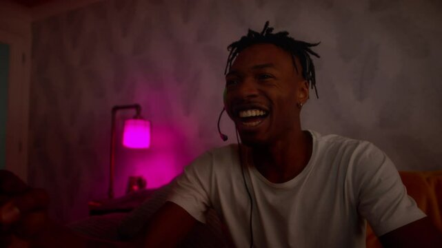 Young black male playing video games celebrates emphatically