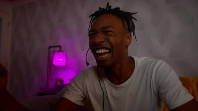 Young black male playing video games celebrates emphatically slow motion