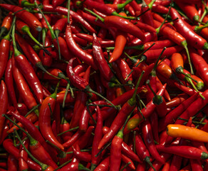 Top view texture of scattered red hot chili peppers, background.