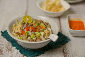 Mie kocok Bandung, Indonesian beef noodle soup served with emping crackers and chili sauce. 