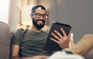 Couch, man and relax with tablet for online, streaming video and social media with smile at home. House, male person and comfortable with digital for reading blog, application subscription or connect