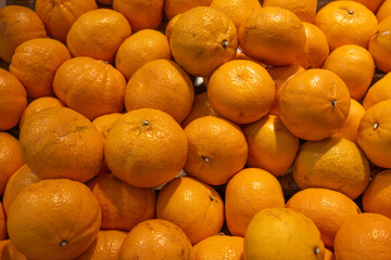 A pile of bright, fresh oranges stacked together, displaying vibrant orange color and textured skin. The image highlights the fruit's freshness and natural appeal.