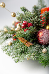 Decorated christmas tree with ornaments and lights, white background for festive holiday designs. Beautiful Christmas wreath decorated with pine cones, berries, red and golden balls