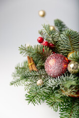 Decorated christmas tree with ornaments and lights, white background for festive holiday designs. Beautiful Christmas wreath decorated with pine cones, berries, red and golden balls