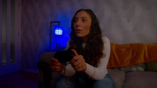 Young Italian woman playing video games celebrates emphatically