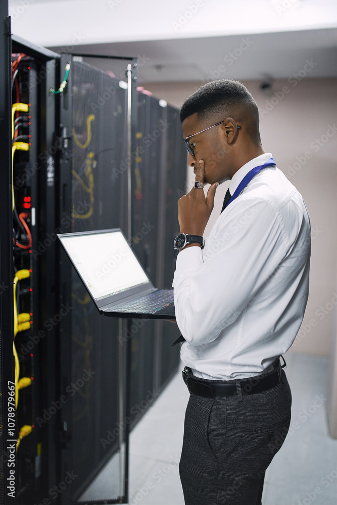Poster Man, technician or thinking with laptop screen in server room for software, hardware or network repair. Male person, IT engineer or wonder with computer for technical problem solving or system backup