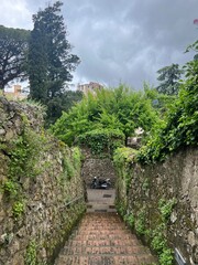 Historic Walkway with Stone Walls Leading to Scooter in a Small Italian Town