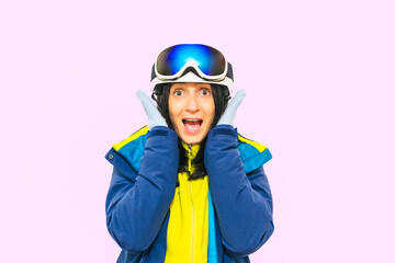 Skier surprised happy fun cool sporty woman in warm purple padded windbreaker jacket goggles mask spend extreme weekend in mountains hold ski sport equipment isolated on plain pink background studio