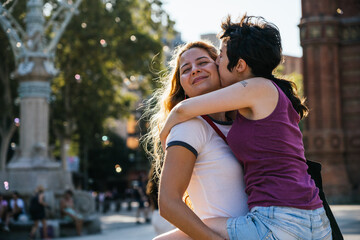 Young lesbian couple sharing a kiss in a city park