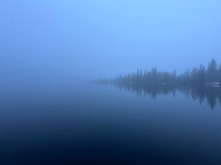 Fototapeta premium Foggy lake with trees