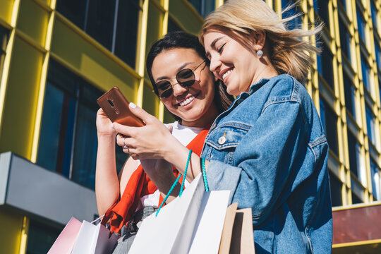 Optimistic woman walking after shopping with friend