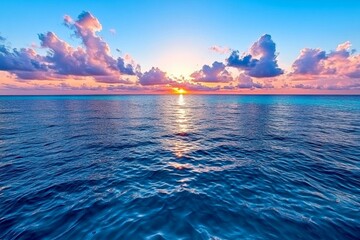 Serene ocean at dawn with soft pink and blue tones reflecting on the calm water