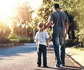 Dad, child and walking on neighborhood street, together and bonding with son on weekend. Father,...