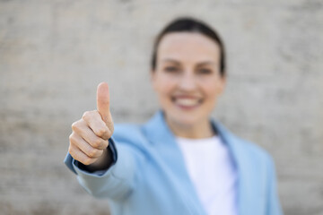 Smiling businesswoman showing thumb up sign of approval