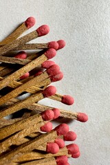  Close-up of several old matchsticks with red tips and sticks scattered across a smooth granite surface.