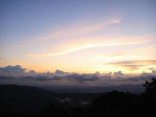 Obraz premium Pastel hues of pink, orange, and blue blend in a serene sunset sky with wispy clouds, evening, serene, landscape