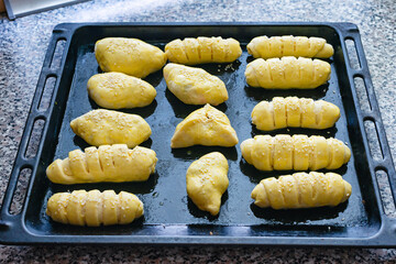 Homemade pies on a baking sheet before cooking in the oven. Cooking homemade pies at home,...