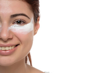 Half portrait of adorable, stylish redhead with cream under eyes, botox effect, fighting with dark circles, looking at camera isolated on white background