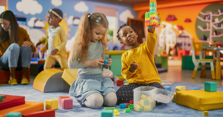 Cheerful Diverse Kids Playing with Colorful Building Block Toys in Kindergarten. Beautiful Black...