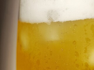 Close up cold beer with bubbles and beer foam