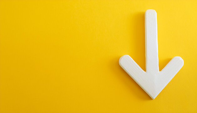White wooden arrow pointing down on yellow background. Business, market decline or economic.