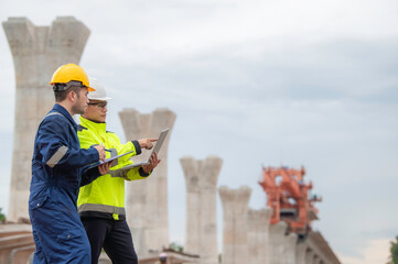 An Asian male engineer works at a motorway bridge construction site,Civil worker inspecting work on crossing construction,Supervisor working at high-speed railway construction site