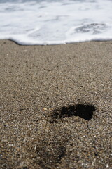 children's footprints in the sand covered by a wave, footprints.......