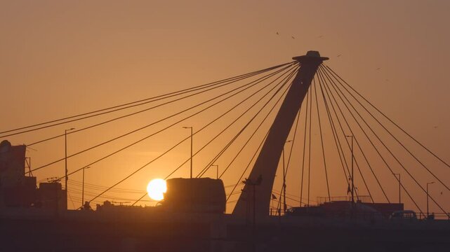 Traffic on architectural landmark Azadi Chowk interchange at sunset in Lahore, Punjab, Pakistan. 
