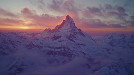 Majestic snow-capped mountain peak illuminated by a vibrant pink and orange sunset with clouds swirling around it.