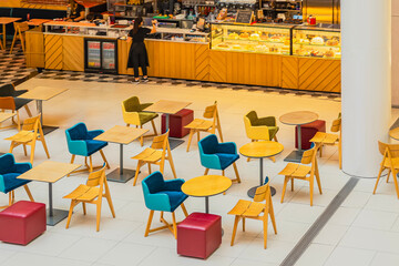 Empty modern cafe interior with colorful chairs, tables, and a bright, inviting design