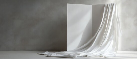 Clothes draped elegantly on a white folding screen against a soft gray backdrop stylish display for fashion photography