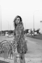 Fototapeta premium Portrait of a young beautiful blonde girl in an urban environment. Black and white photo.